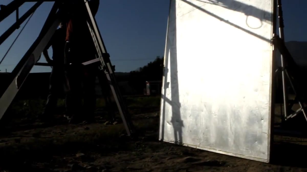 Assistant positioning reflective shiny board toward talent