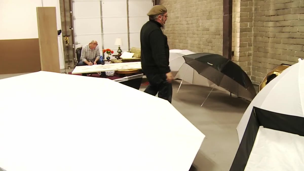 The 60-inch convertible umbrella with black backing being demonstrated