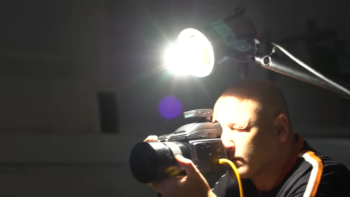 Bare bulb studio light positioned just above camera