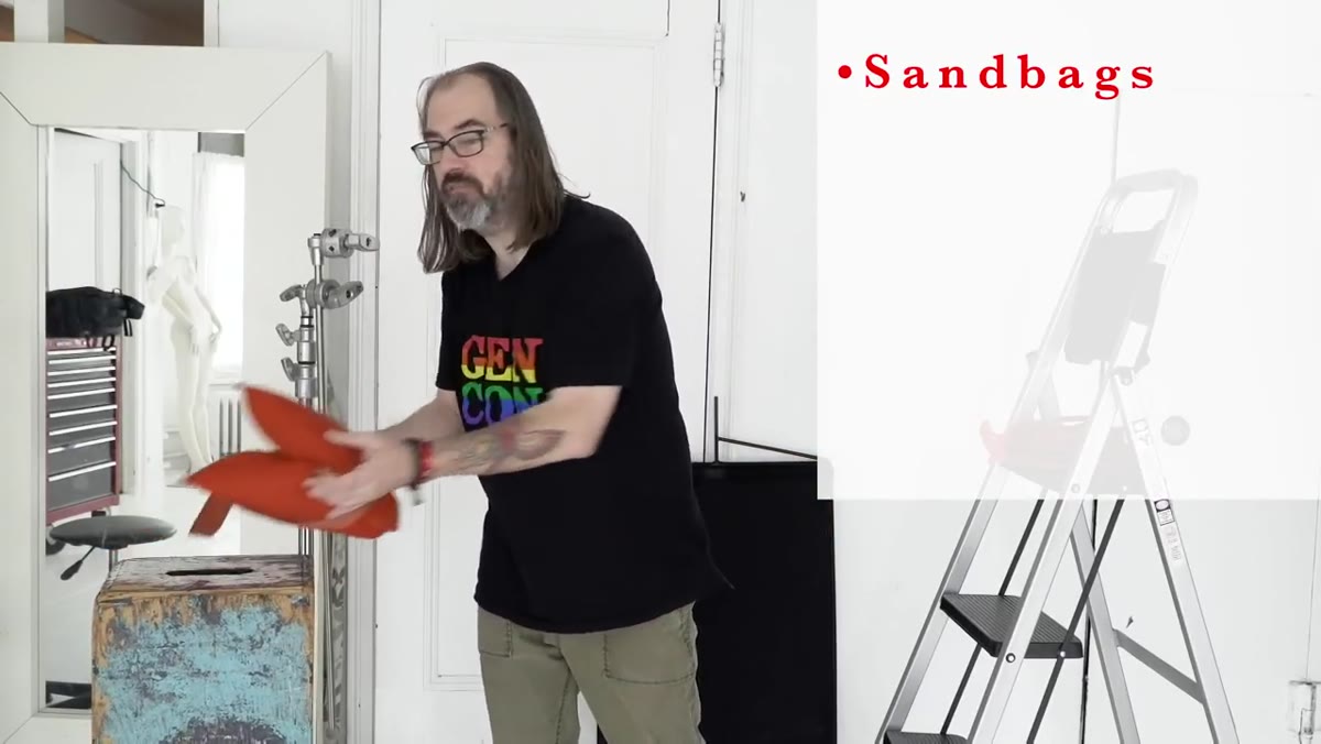 Matthews 25-pound orange sandbag held up to camera