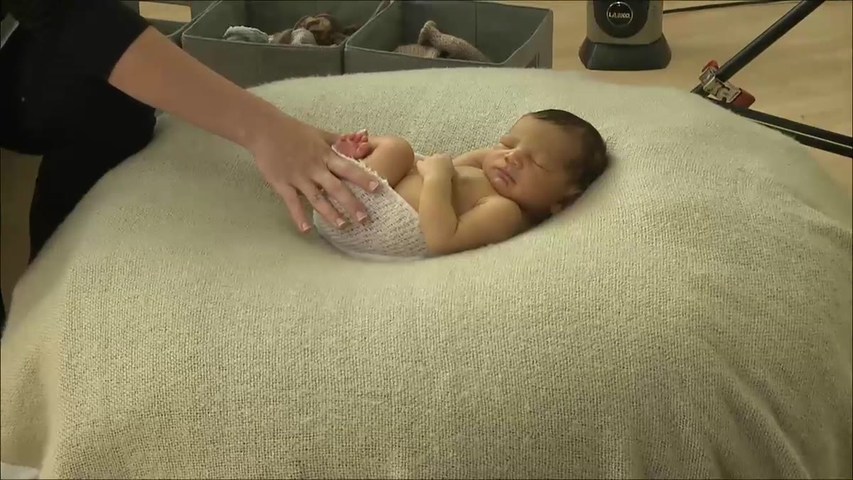 Kelly Brown turning newborn toward window light source