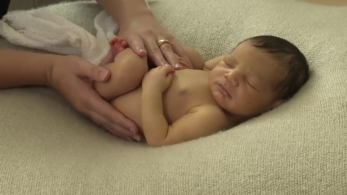 Kelly guiding baby&rsquo;s bottom and elbow simultaneously through turn