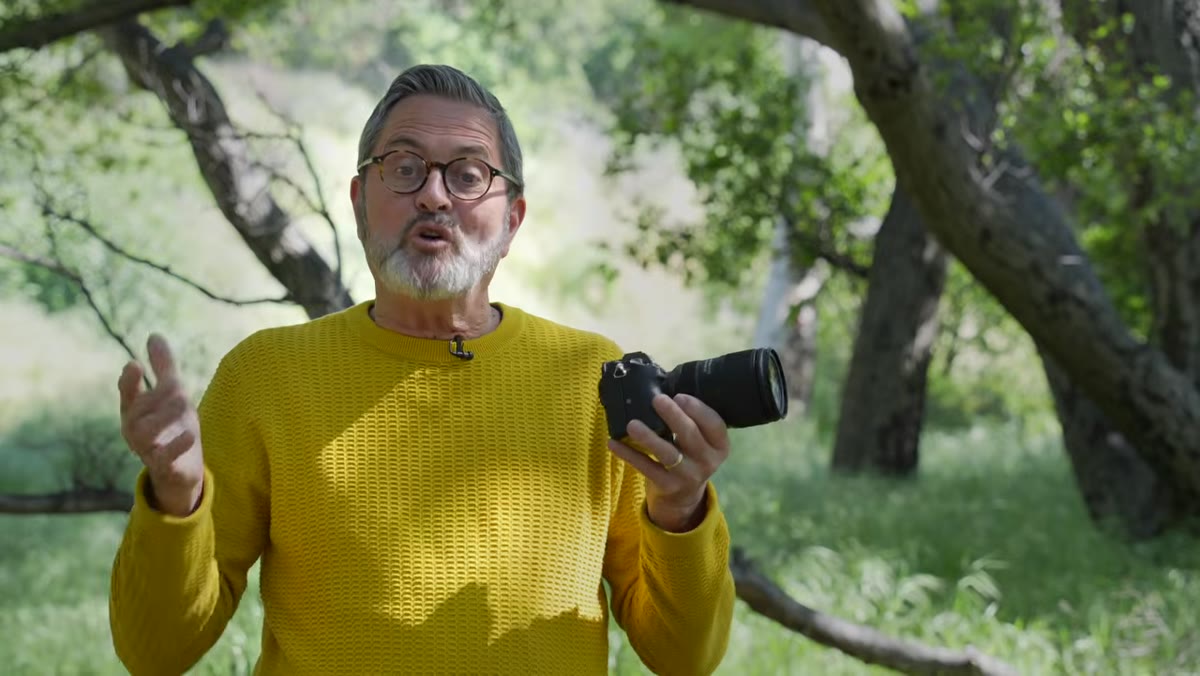 Jay holding a 28-75mm lens and explaining focal range