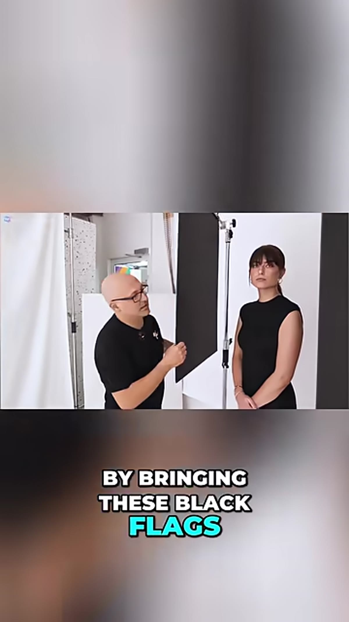 Hands holding black foam board panel next to subject