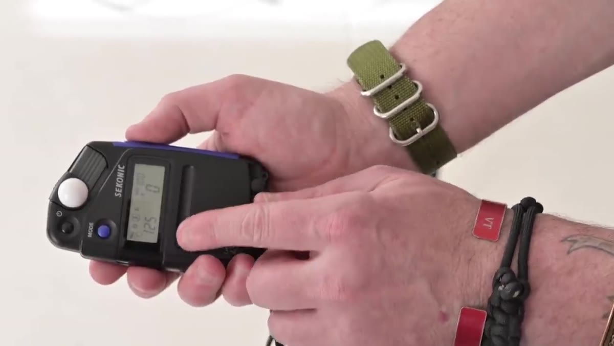 Light meter held up with flash mode active, waiting for test flash trigger