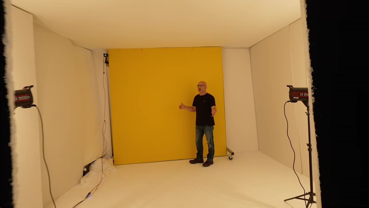 Yellow background visible with two bare bulb lights in frame