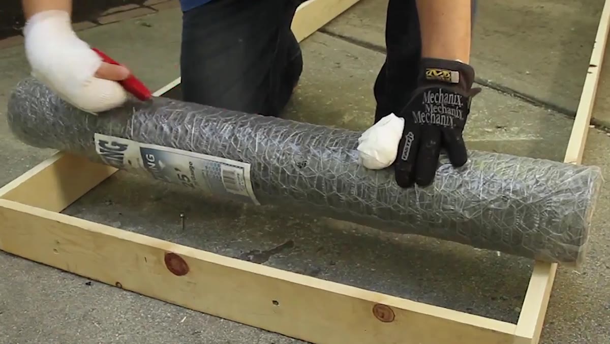 Stapling one-inch chicken wire flat across the wooden frame