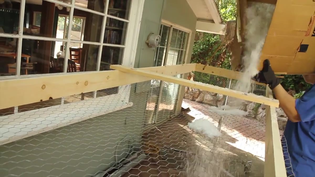 Pouring plastic snow onto the chicken wire mesh