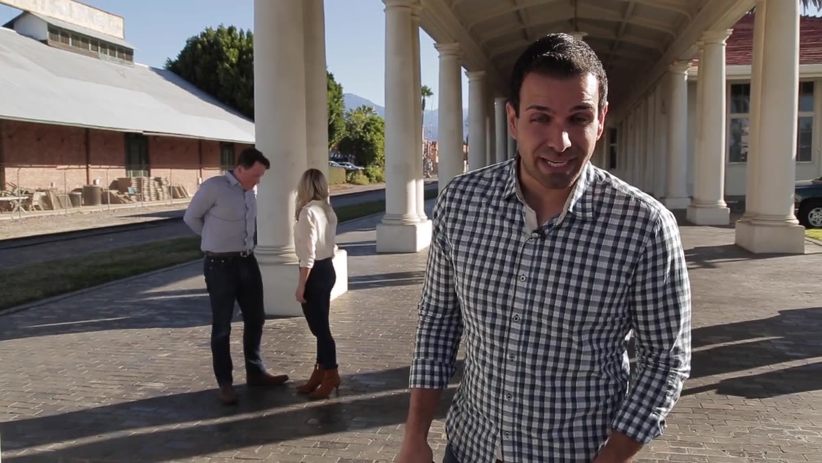 Photographer adjusting camera settings before positioning couple