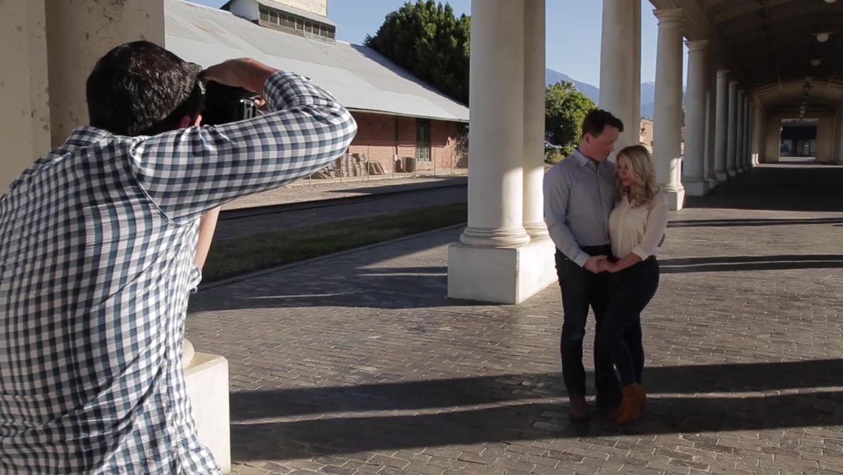 Photographer directing female subject to look toward camera, chin angled