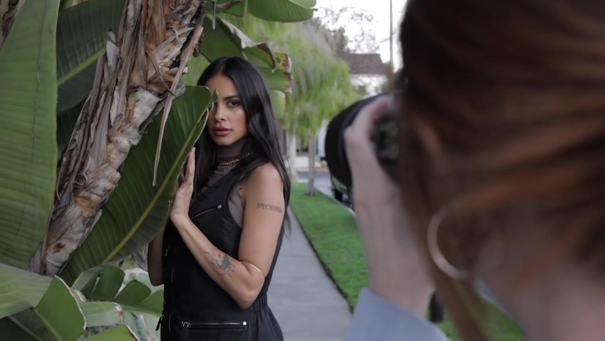 Model holding a leaf partially across her face