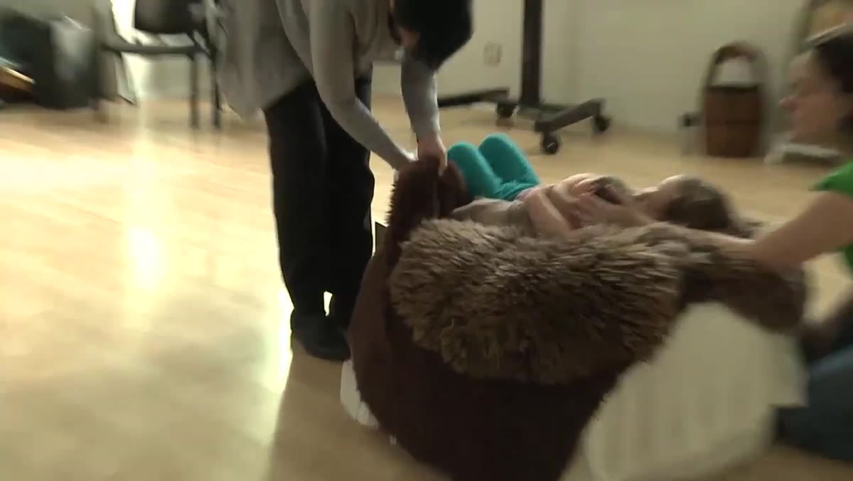 Cloth nappies being tucked under the baby and the sibling&rsquo;s arm
