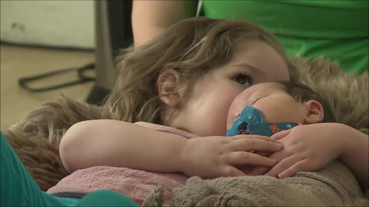 Photographer adjusting baby&rsquo;s nose angle toward window light