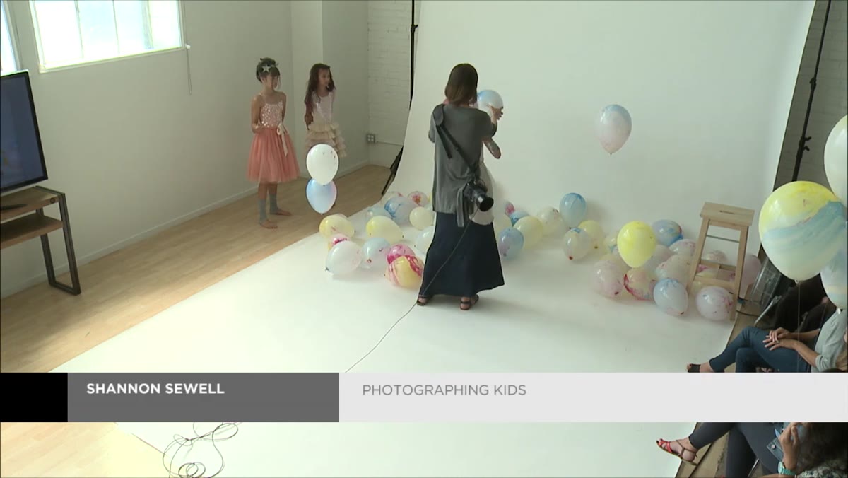 Photographer positioning child&rsquo;s hands around a chalk balloon