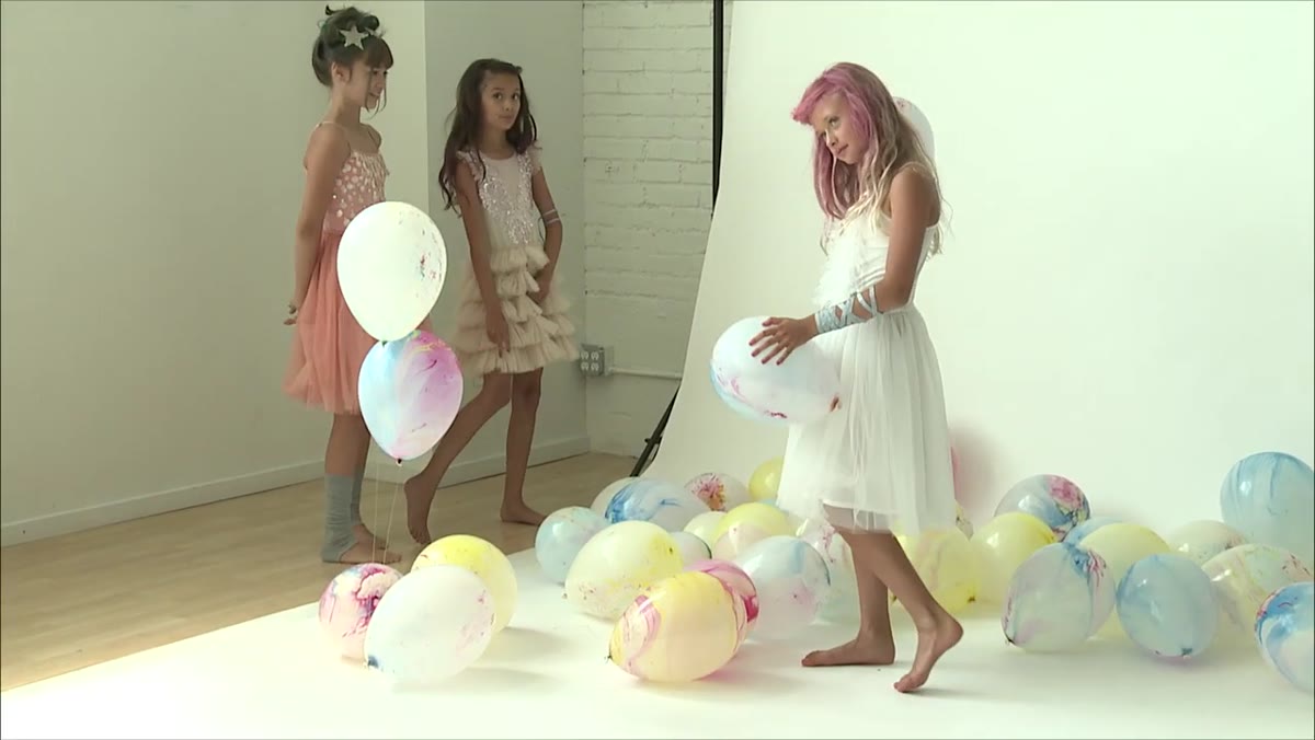 Photographer repositioning angle to prevent balloon appearing behind child&rsquo;s head
