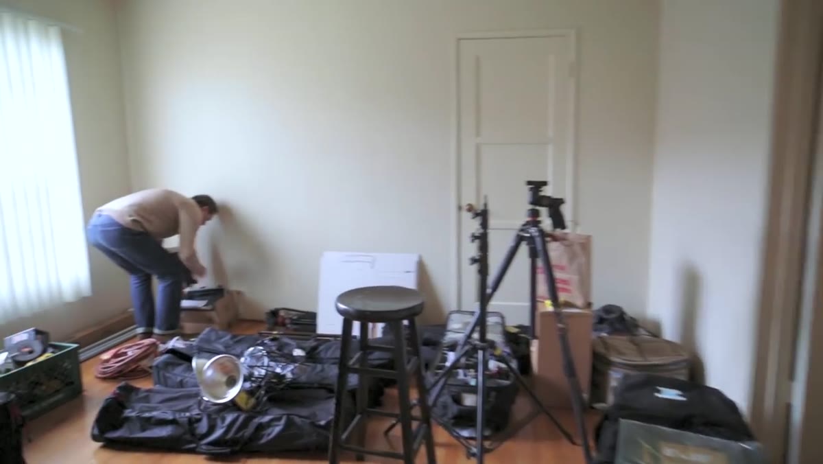 Jay P. gesturing at neutral-colored bedroom walls