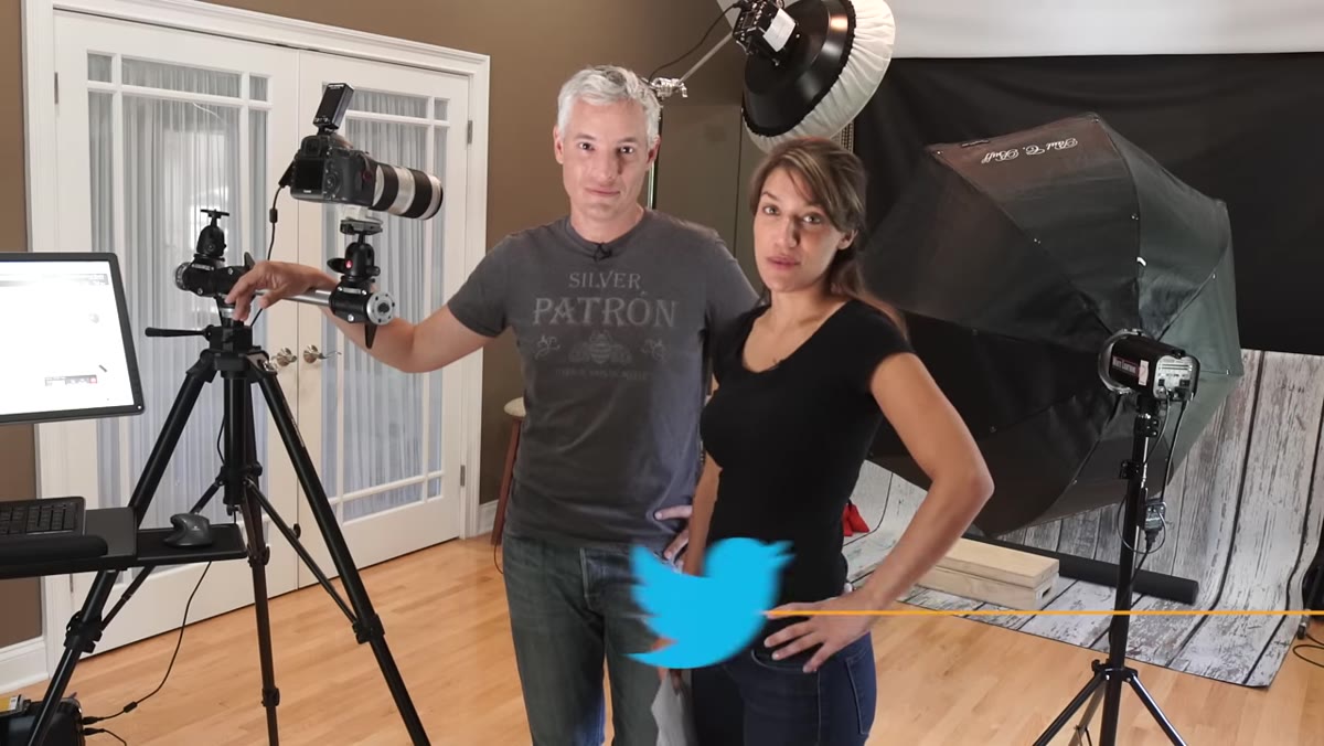 Camera mounted on Manfrotto tripod next to rolling monitor cart