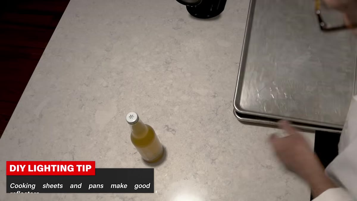 Worn cookie sheet being positioned as background behind bottle
