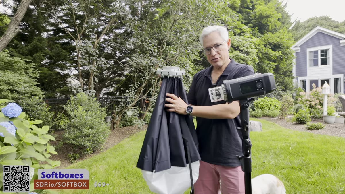 Softbox being expanded and attached to strobe outdoors