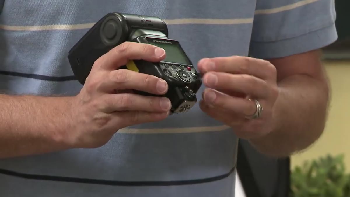 Instructor sets Nikon flash switch to master position on hot shoe