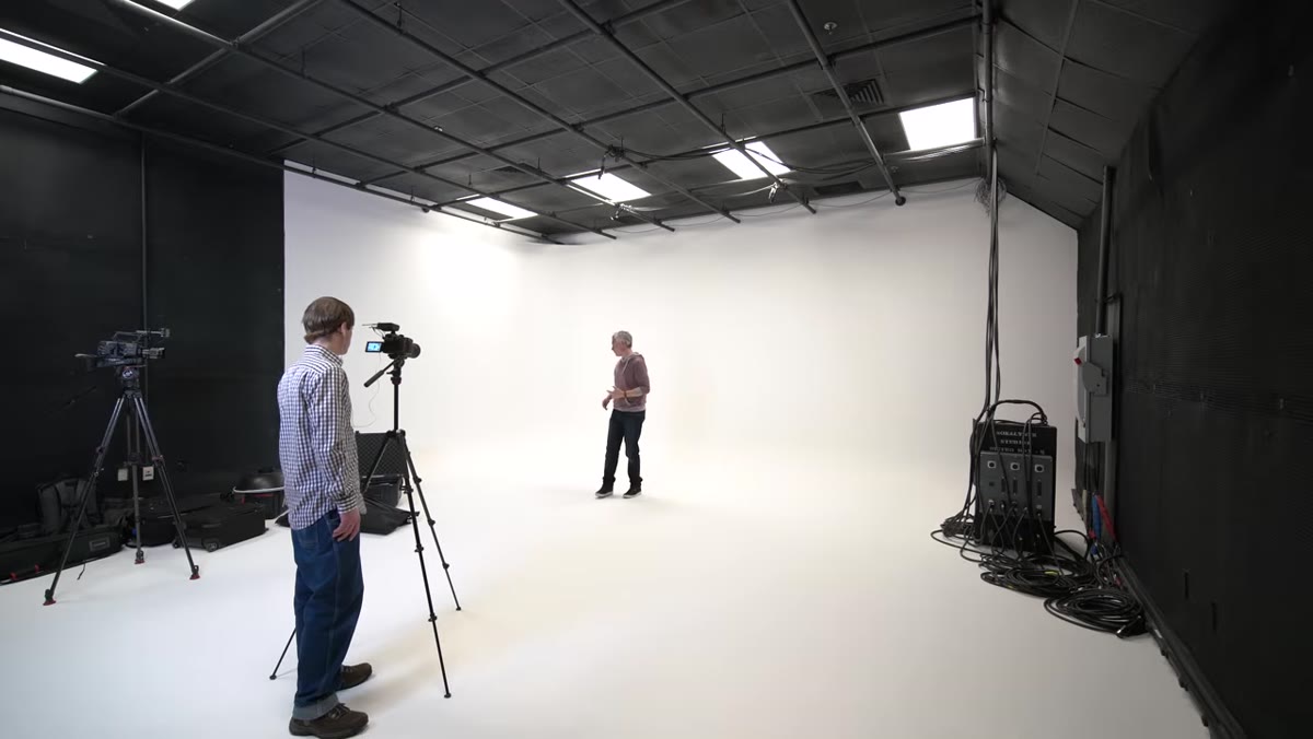 Wide shot showing black-painted walls surrounding the white cyc