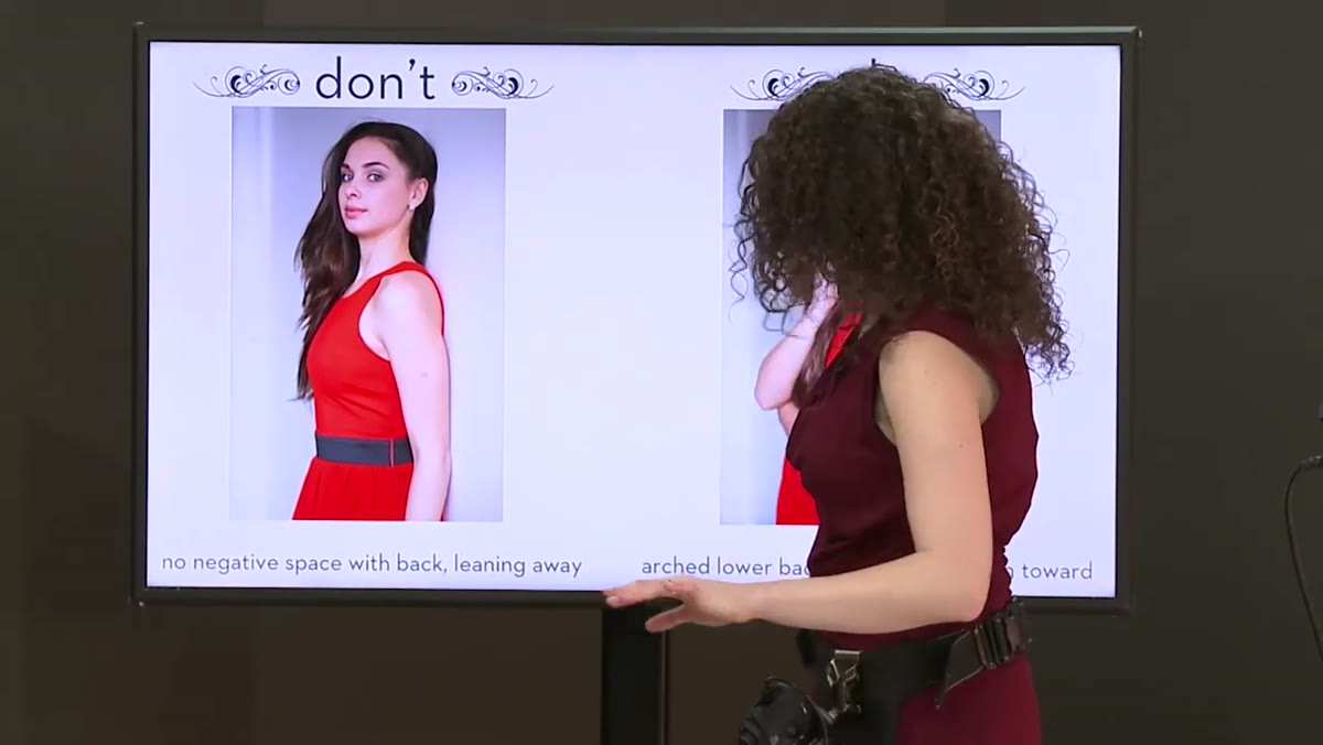 Subject&rsquo;s hand placed behind her, elbow angled outward from wall