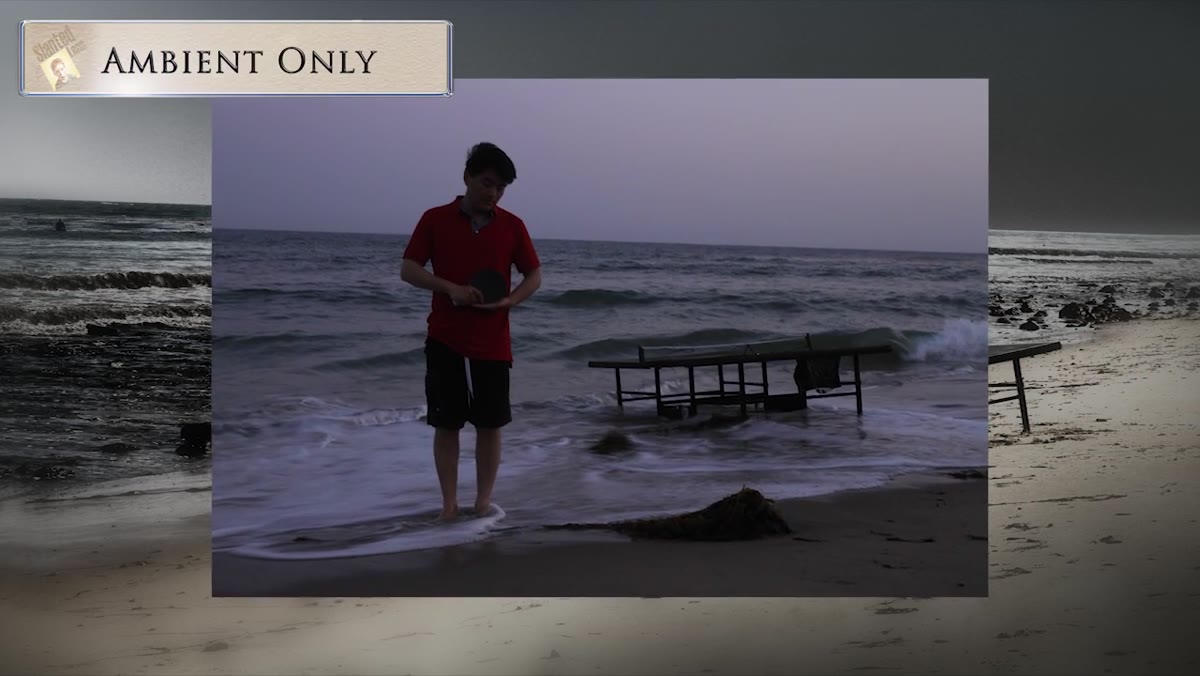 Bare strobe head positioned behind ping pong table on beach