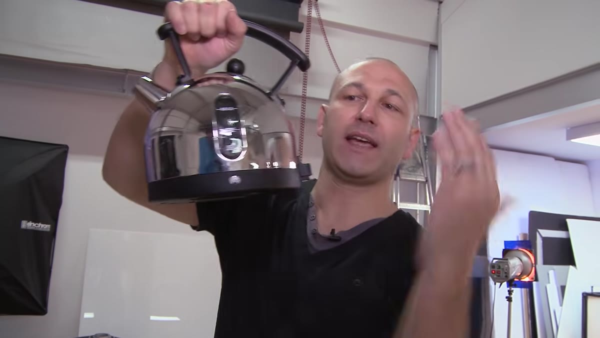 Chrome kettle reflecting studio, operators, and ceiling