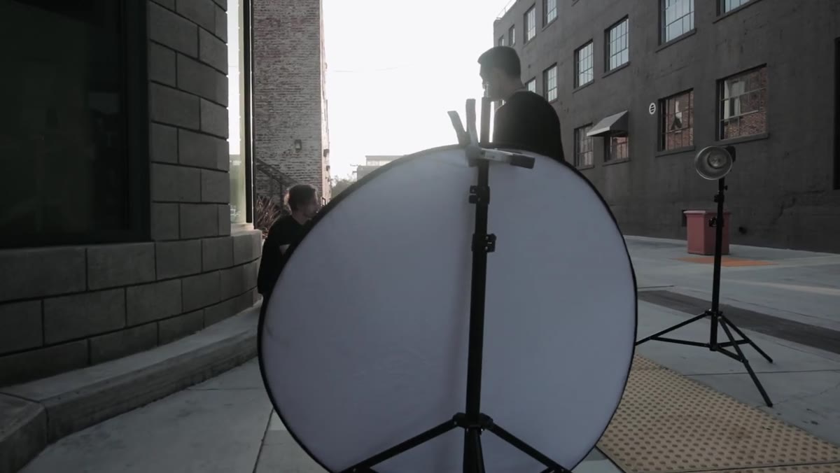 Strobe and reflector positioned in front of subject outdoors