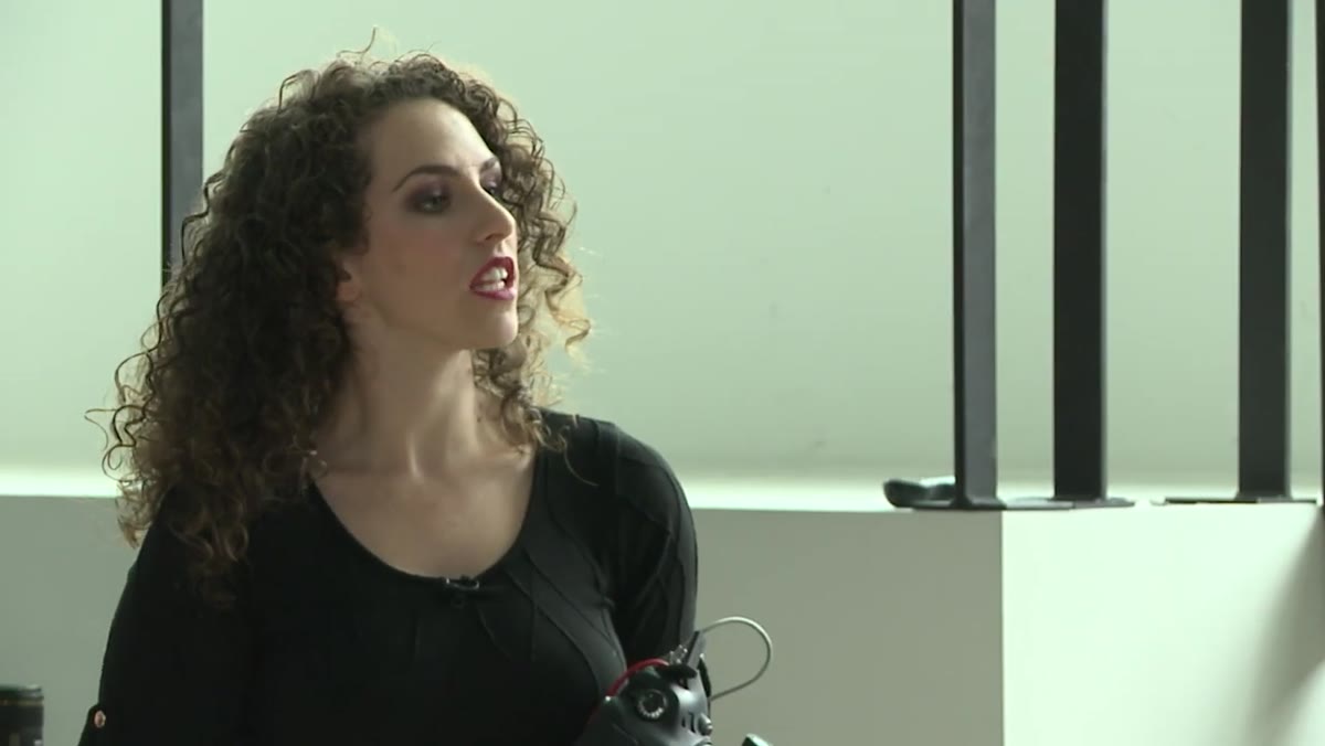 Photographer directing model to sit up straight and lean forward