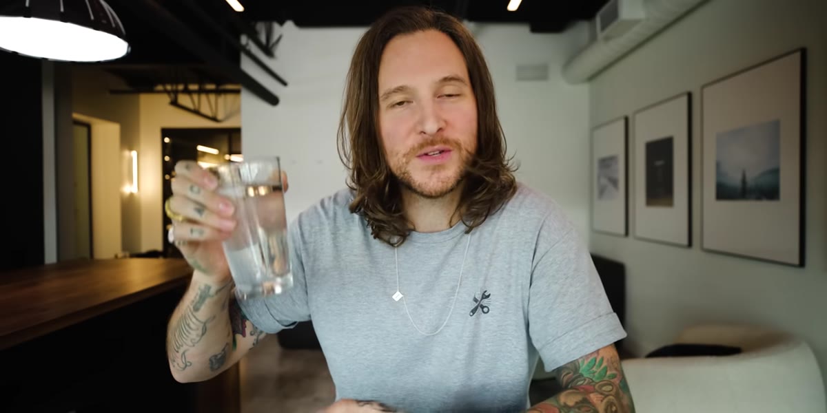 Sparkling water poured into pint glass on desk
