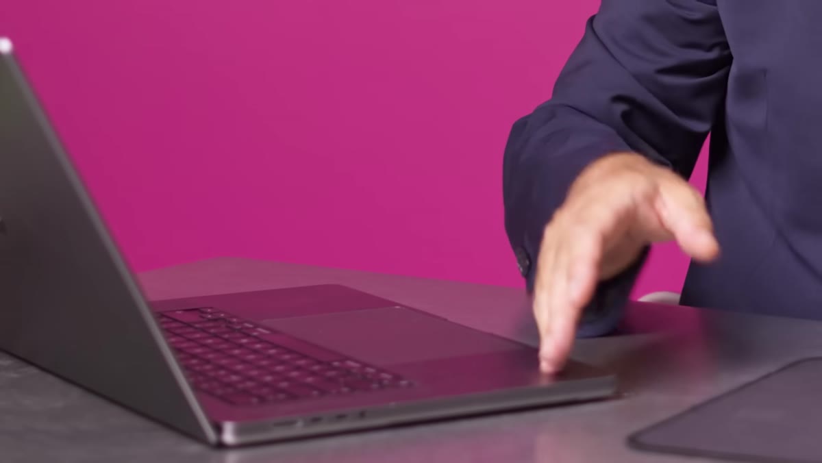 Laptop surface reflecting hand and fingers in diffused metal finish