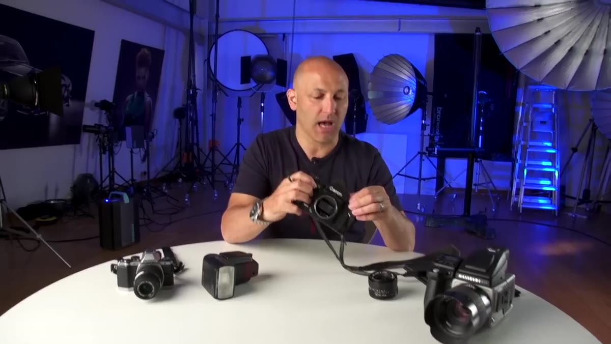 Karl holding open-back Canon F1 film camera toward lens